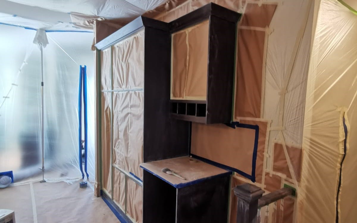 Kitchen cabinets which are prepared for spray painting, it shows an area that looks like a built in or pantry