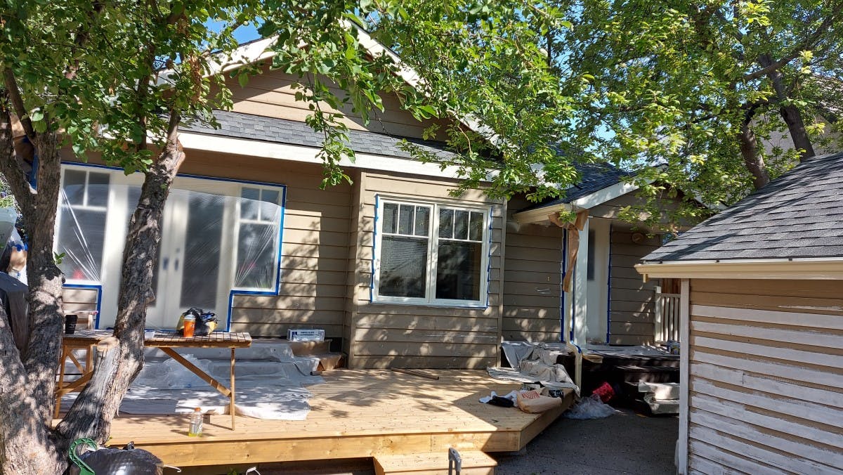 exterior siding of a house  being prepared for exterior painting ,back side of the house, the actual colour is light brown, in Calgary