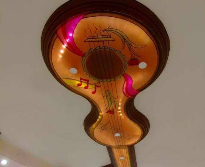 Ceiling bulkhead in the shape of a guitar, its been painted just like a guitar, it has lights inside so its very colourful
